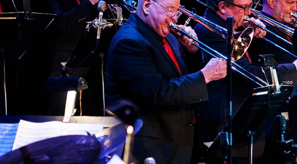 A trombonist playing a solo during a swing era jazz standard.